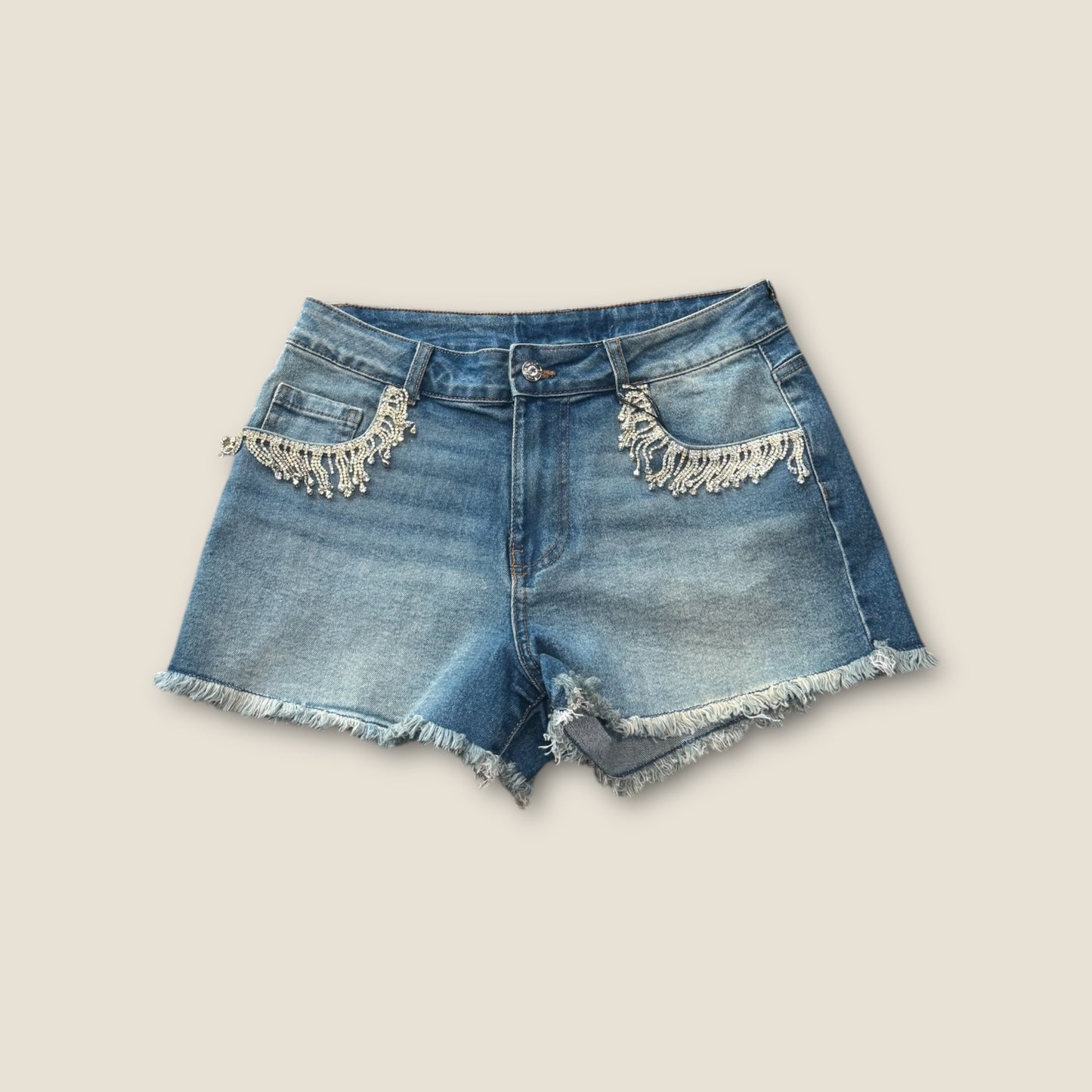 Pantalón corto vaquero con flecos de pedrería en bolsillos