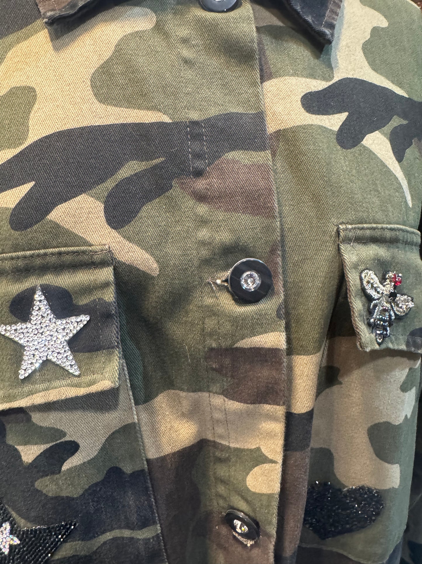 Sobre camisa camuflaje alas negras y cruz de pedrería