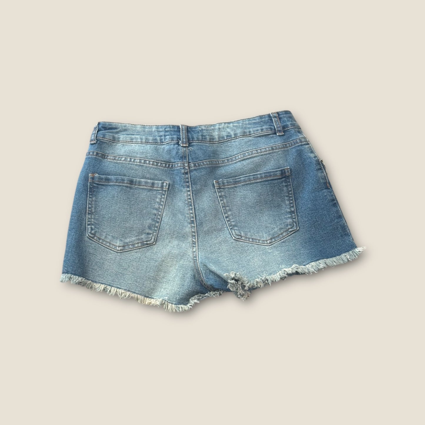Pantalón corto vaquero con flecos de pedrería en bolsillos