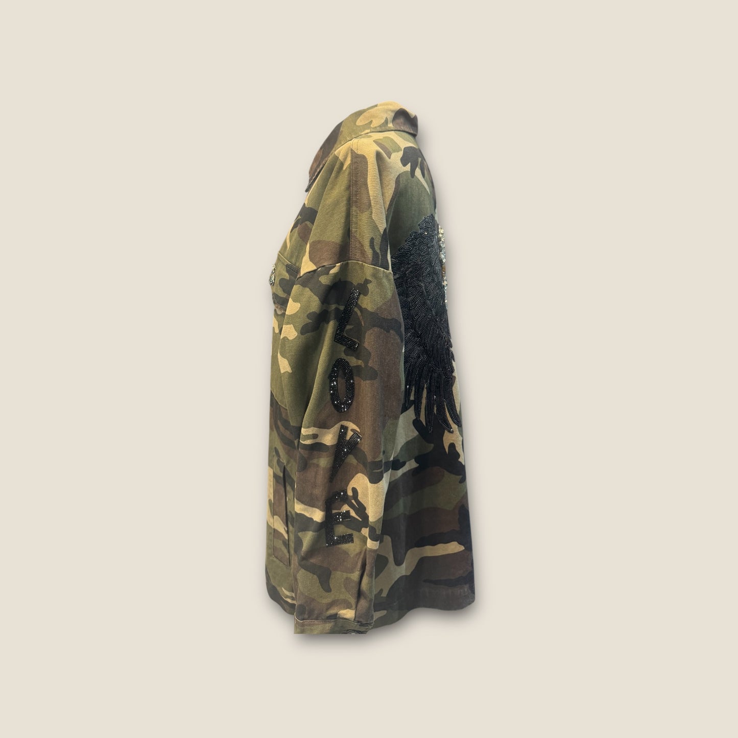 Sobre camisa camuflaje alas negras y cruz de pedrería