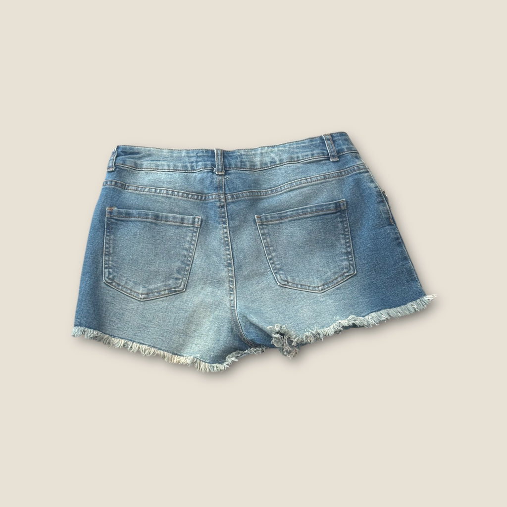 Pantalón corto vaquero con flecos de pedrería en bolsillos